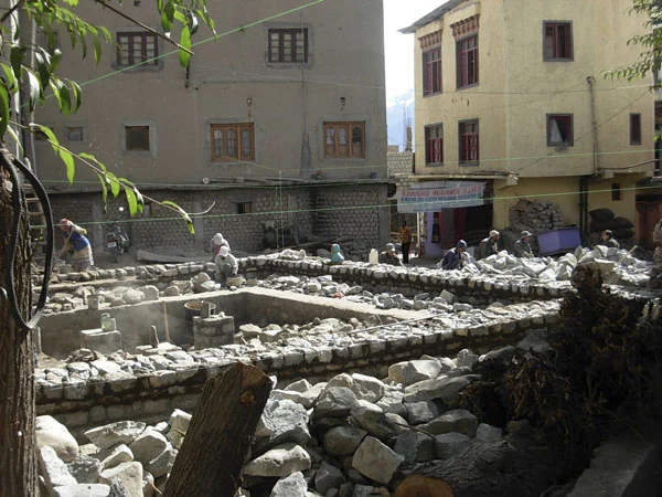 The artisan team begins the solid stone walls.