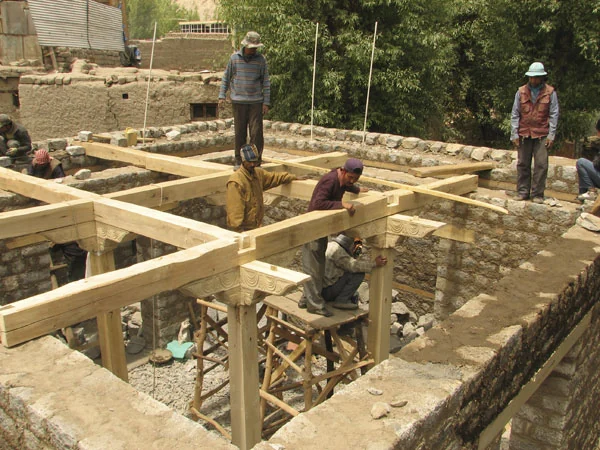 Carpenters assemble the pillars, brackets and beams.