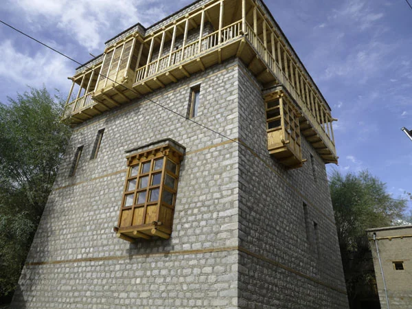 The museum tower with its tall, thin, asymmetrically placed windows and a timber bay window